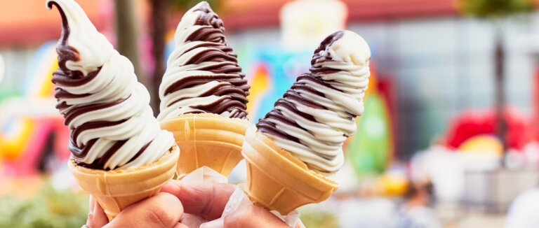 Three hands holding ice cream. Chocolate vanilla ice cream in wa